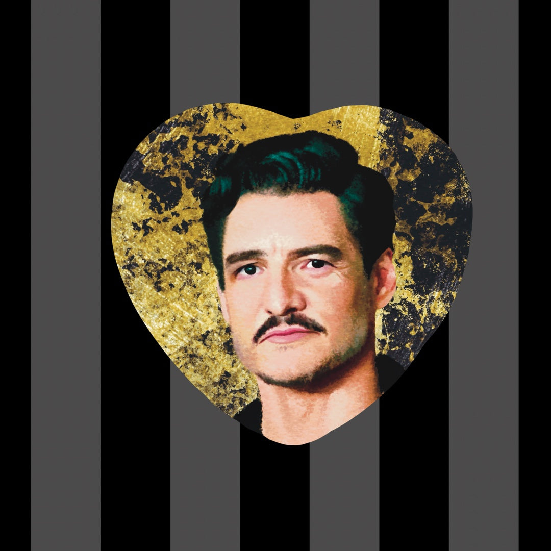 Item is a heart shaped button of Pedro Pascal with golden toned background. Background is a pink toned sequin fabric.