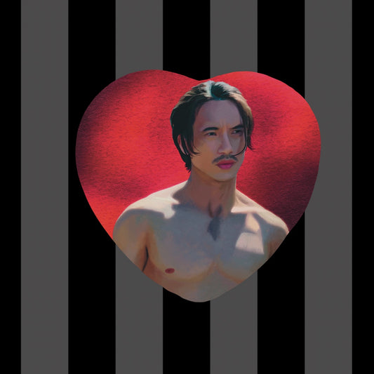 Item is a heart shaped button of Manny Jacinto as Qimir from The acolyte with a bright red background.