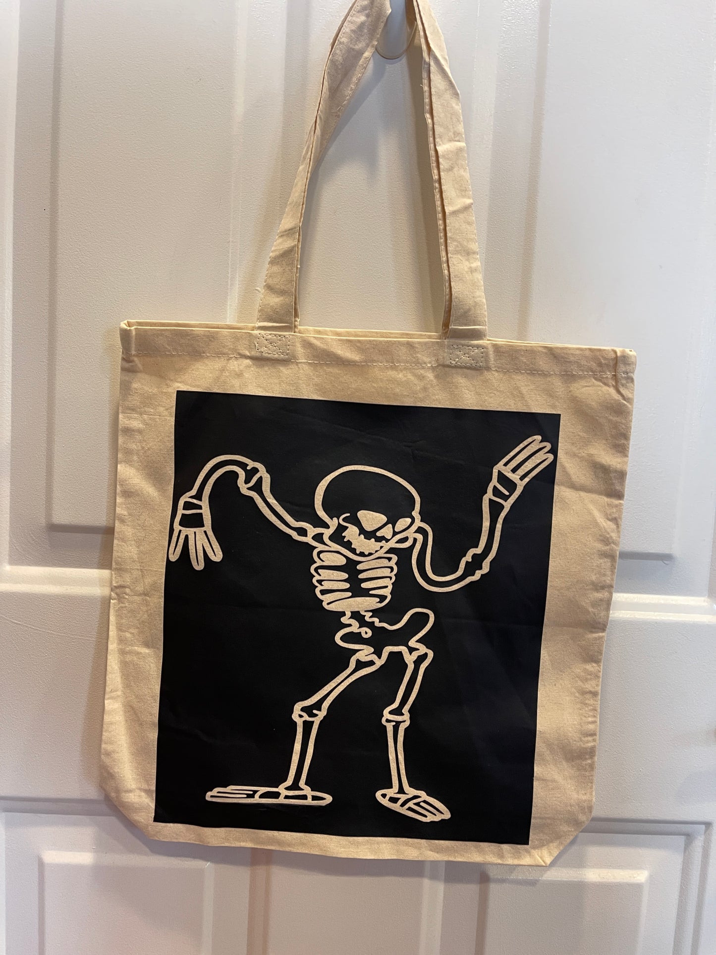 Canvas tote bag with a cartoon skeleton dancing design in black