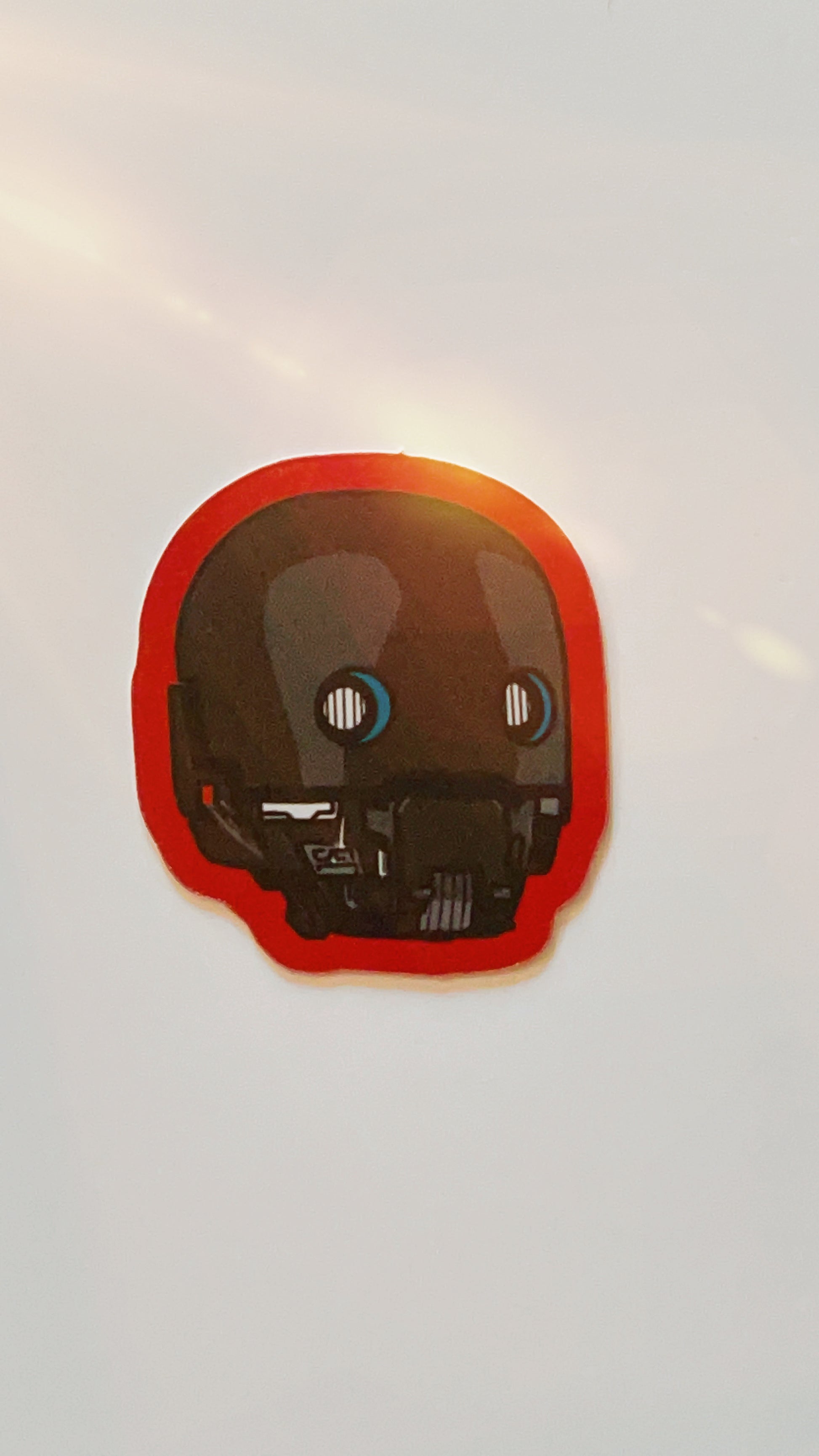 Vinyl sticker of star wars droid k2s0 with red edges.