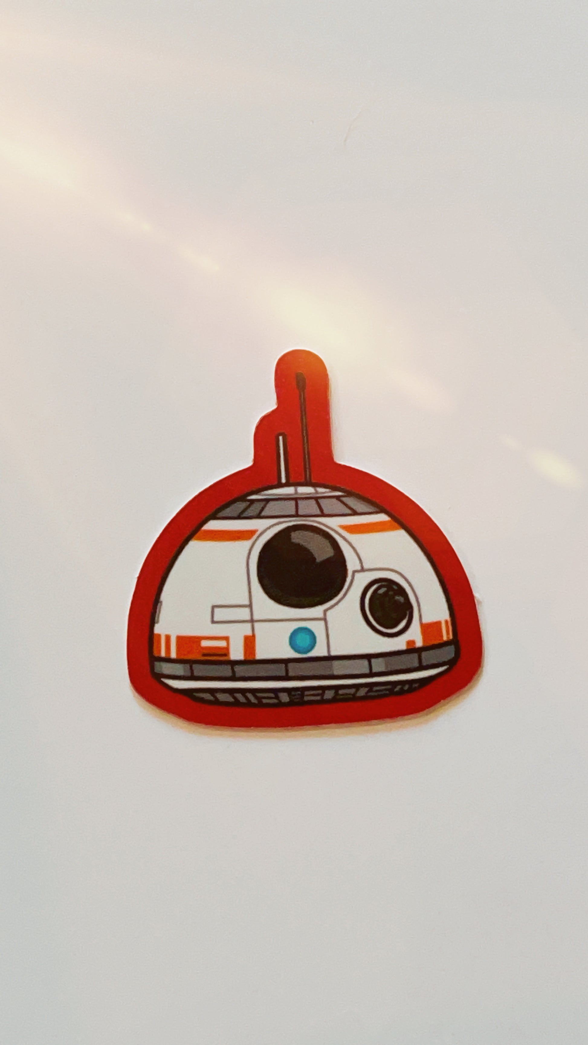 Vinyl sticker of star wars droid bb8 with red edges.