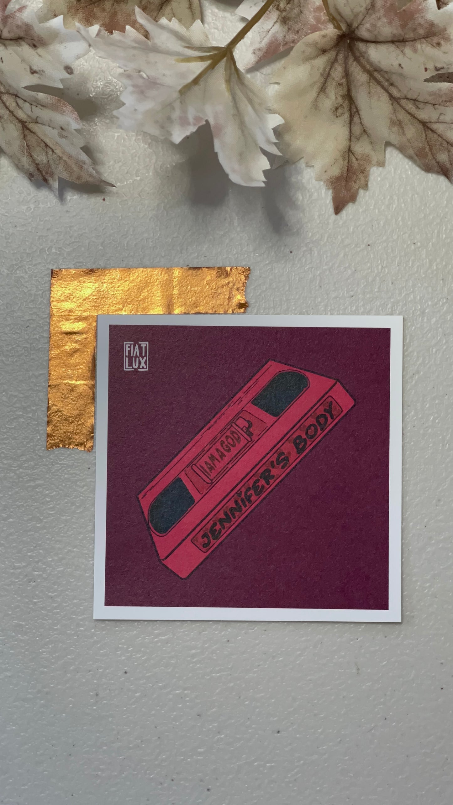 Art print of a pink VHS tape of Jennifer's Body on a solid burgundy background.