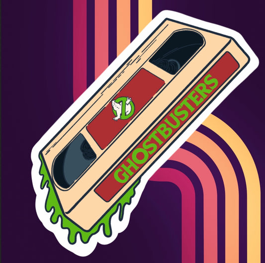 acrylic pin of a beige VHS tape of ghostbusters with a single backing post