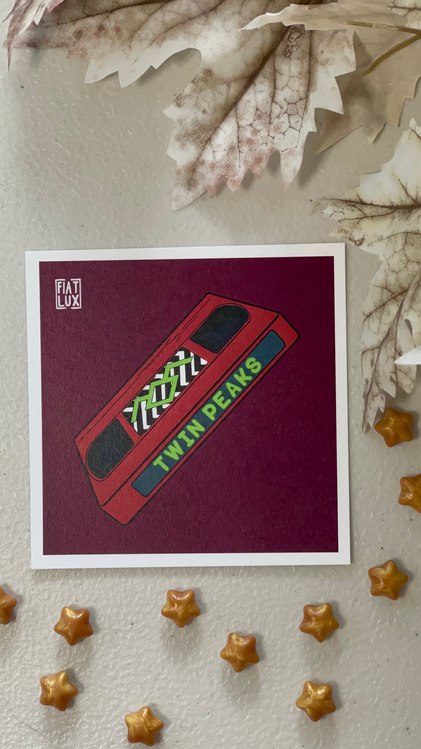 Art print of a red VHS tape of Twin Peaks on a solid burgundy background.