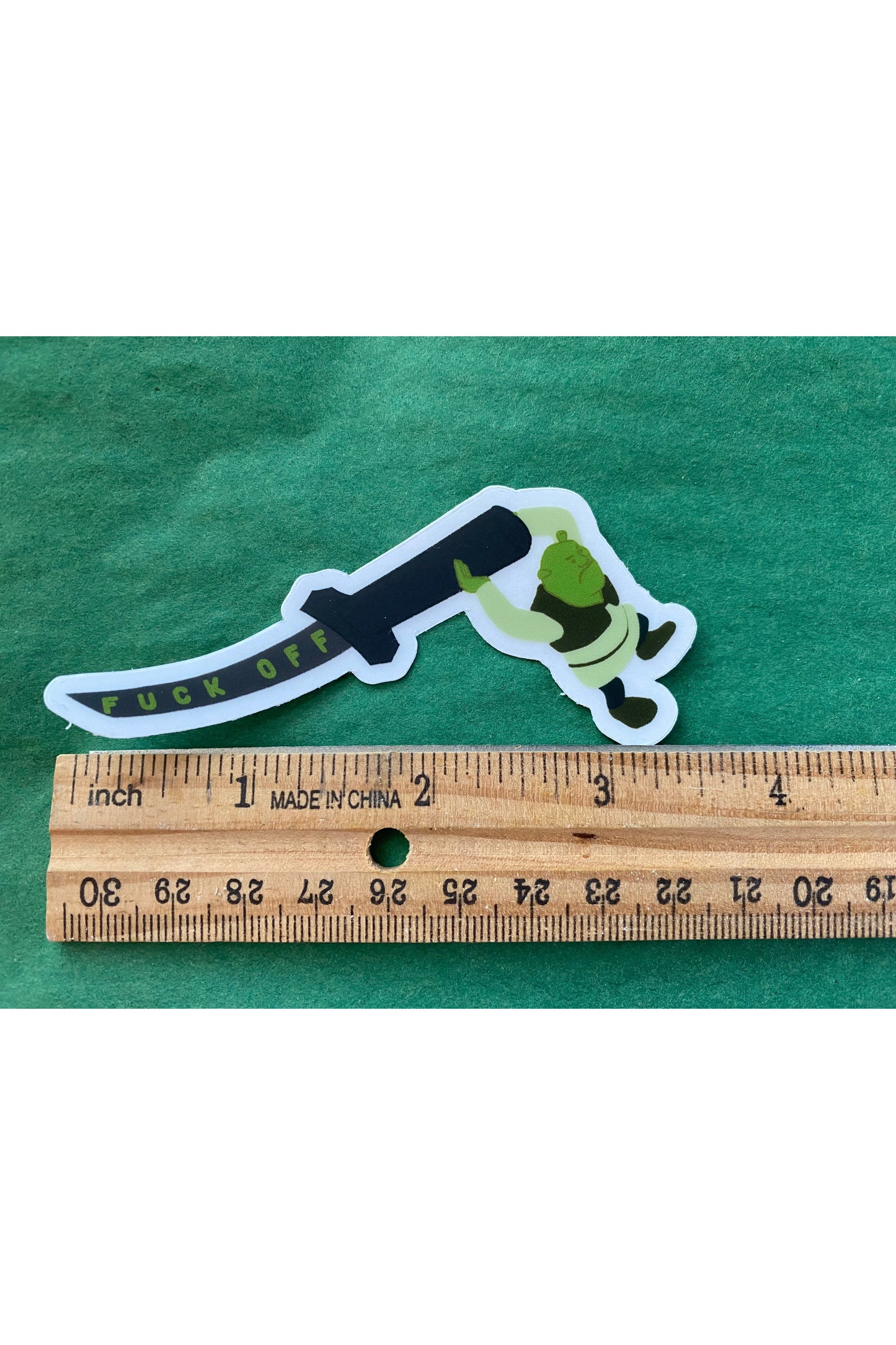 vinyl sticker of shrek holding a katana that reads fuck off in green text down the blade