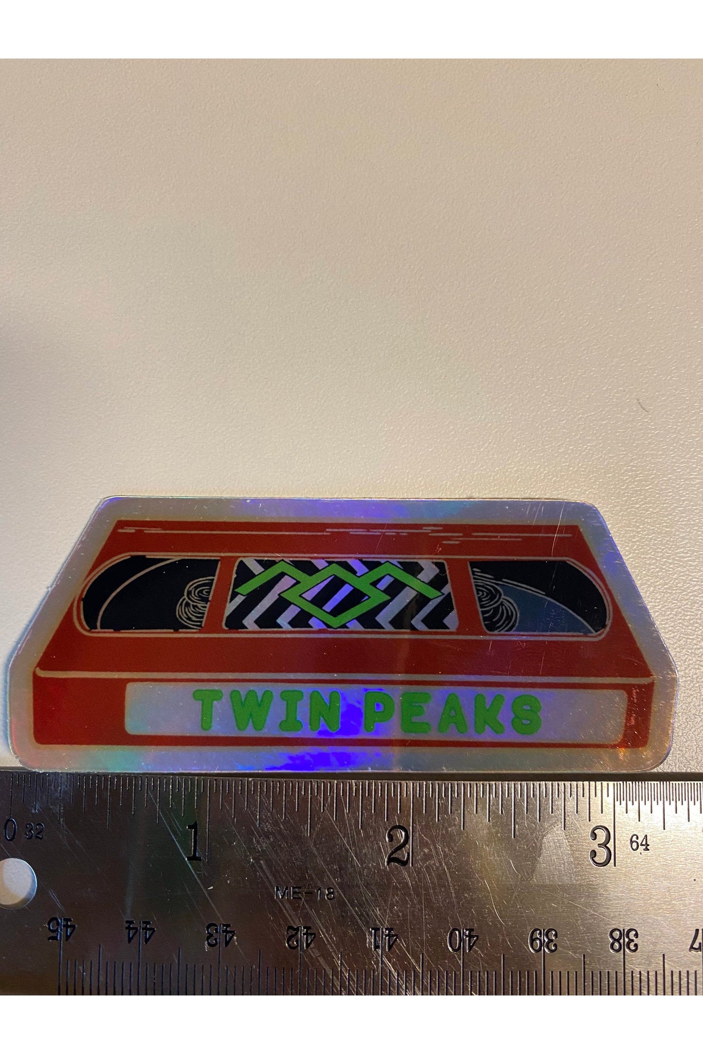 sticker of a red VHS tape of twin peaks in holographic vinyl