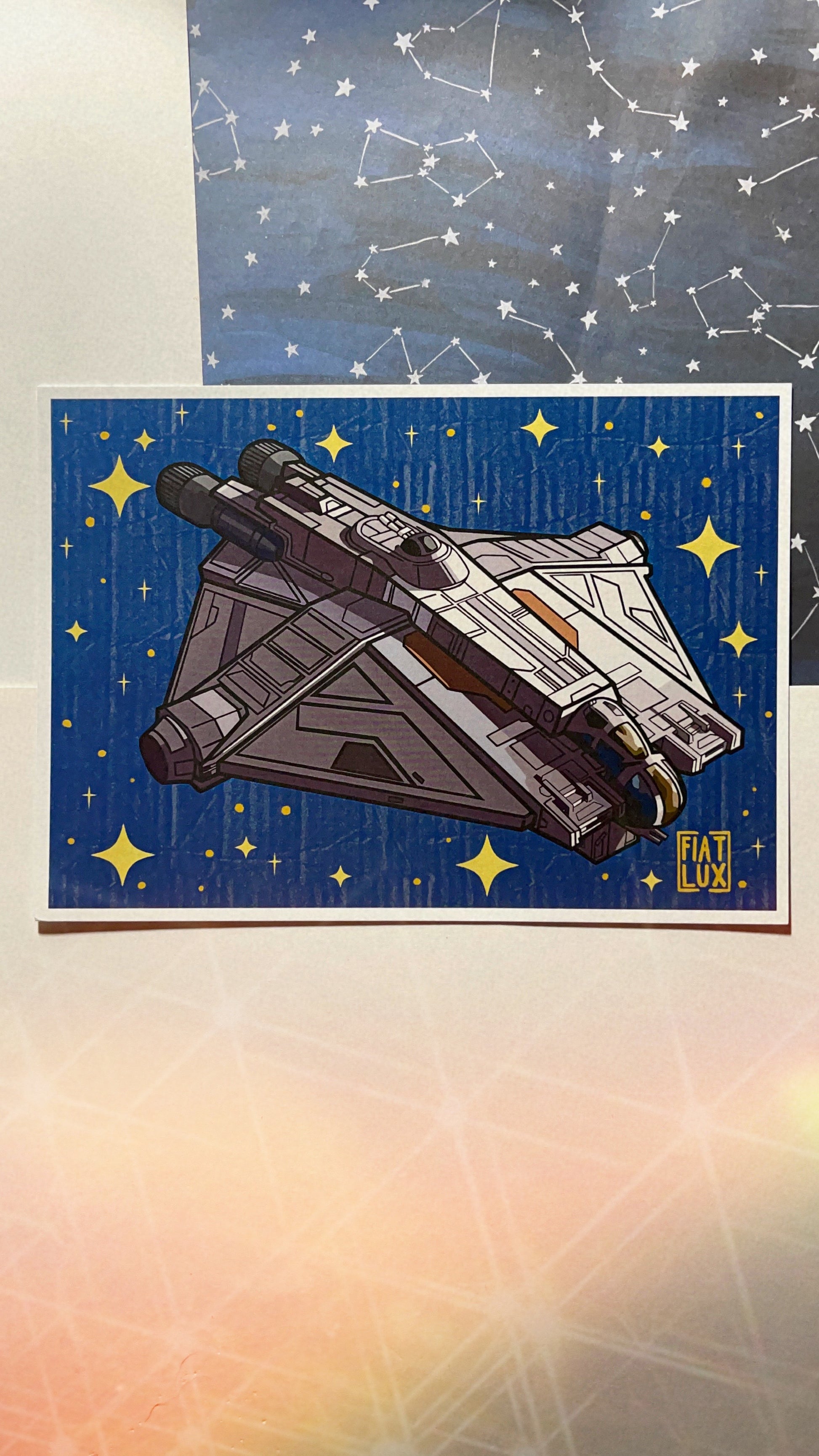 Art Print of hera syndulla's star fighter the ghost with a solid blue background with gold stars and a paper texture overlay