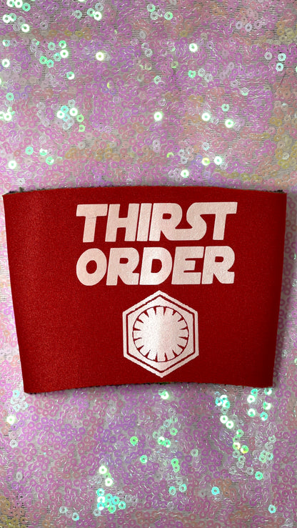 Item is can cooler koozie in bright red with white text reading Thirst Order and the First Orders logo. Background is a pink toned sequin fabric.